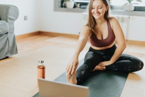 Limpieza de pisos en casa con servicio profesional de hotcleaner en México. Mujer haciendo estiramiento post limpieza, ambiente limpio y ordenado en sala. Servicios confiables de limpieza y mantenimiento.