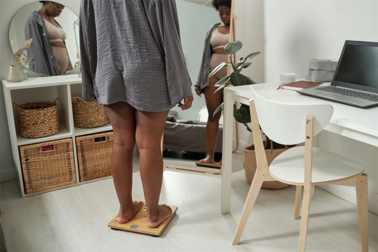 Balanza de peso digital para control de peso y salud. Mujer en la balanza en un ambiente de oficina en casa con diseño moderno. Ideal para monitorear peso y bienestar personal.