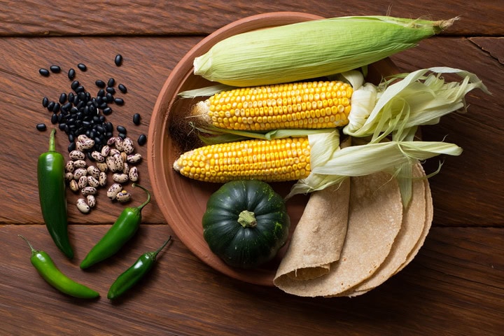 Verduras y granos frescos en plato de cerámica, ideales para recetas saludables y pérdida de peso.