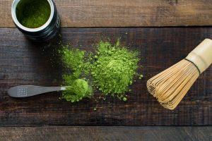 Polvo de té verde matcha en polvo y utensilios tradicionales para preparar bebidas saludables.