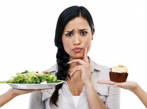 No apta para pérdida de peso, mujer confundida con postre y ensalada en manos, decisiones dietéticas difíciles, opciones saludables versus comida indulgente, elecciones en la dieta.
